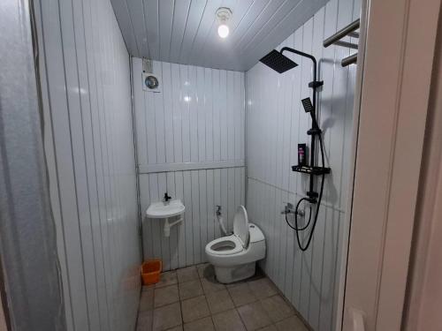 a small bathroom with a toilet and a shower at Hillside guest house and restaurant in Gitgit