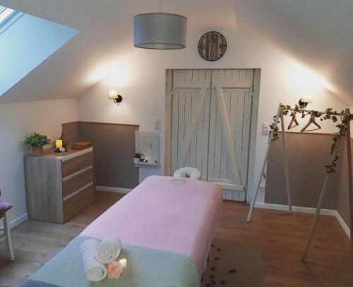 a room with a bed and a clock on the wall at Gîte "Le Sablon" à Unchair - Appartement de charme & prestations bien-être - A 20 mn de Reims centre in Unchair