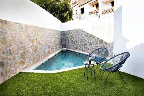CáñarにあるOasis de Cañarの庭園に椅子2脚とテーブル1台付きのプールがあります。