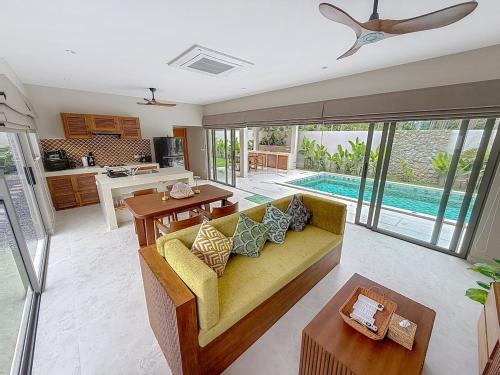 een woonkamer met een gele bank en een keuken bij Villa Souimanga 2Bed Balinese style Garden & Pool in Mae Nam