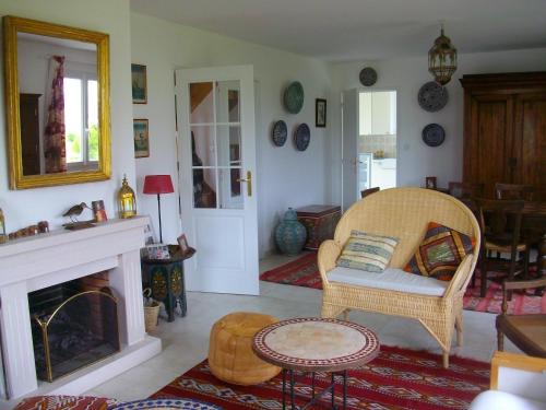 a living room with a chair and a fireplace at Maison d'Aude in Brignogan-Plage