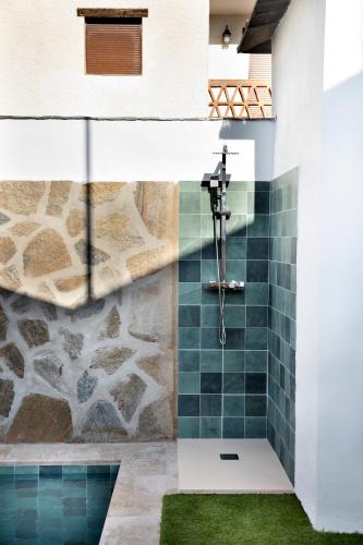 a shower in a bathroom with green tiles at Oasis de Cañar in Cáñar