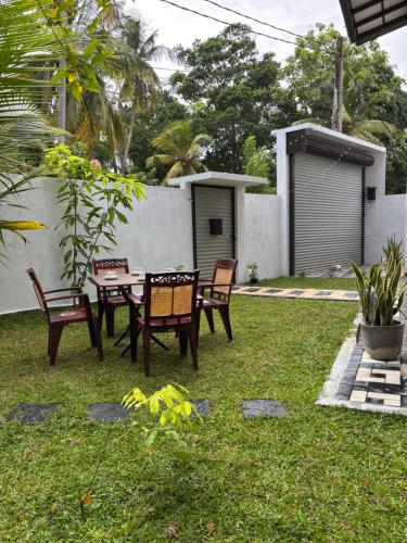 a yard with a table and chairs and a fence at Villa southern coast in Kamburugamuwa
