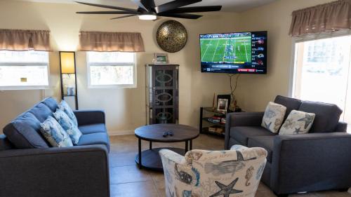 a living room with two couches and a flat screen tv at Four Bedroom Two Level Home Near Beach in South Padre Island
