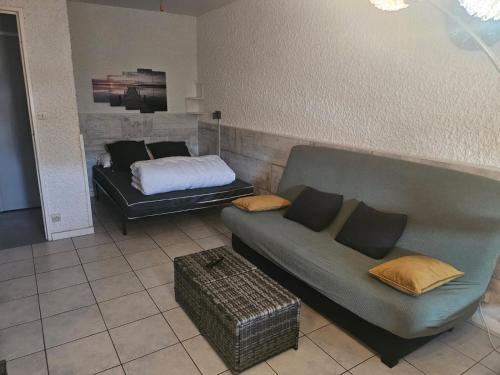 un salon avec un canapé et un lit dans l'établissement PALMA II, à Port-la-Nouvelle