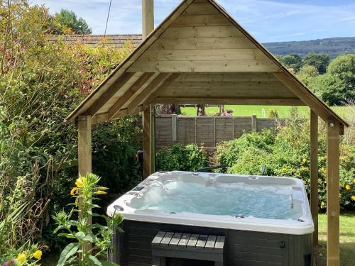a hot tub in a gazebo in a garden at New House Farm Annexe in Neenton