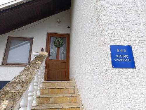a sign on the side of a building with a door at Studio Apartman Ivan in Otočac