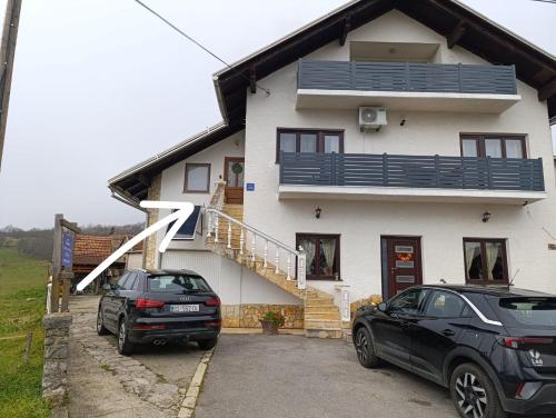 two cars parked in front of a house at Studio Apartman Ivan in Otočac