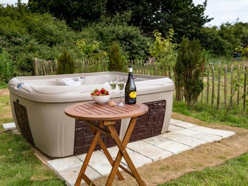 a bottle of wine sitting on a table next to a bath tub at Bay in Wootton Bridge
