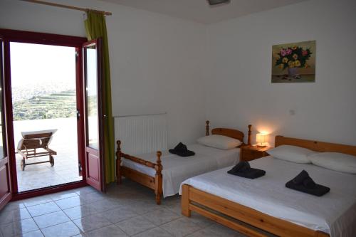 a bedroom with two beds and a balcony at Lefkes Horizon in Lefkes