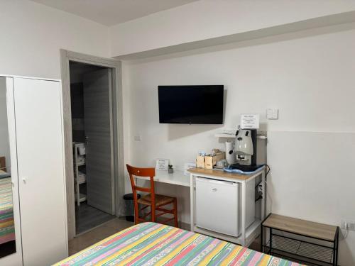 a hotel room with a bed and a desk and a television at B&B IL GIRASOLE in Maddaloni
