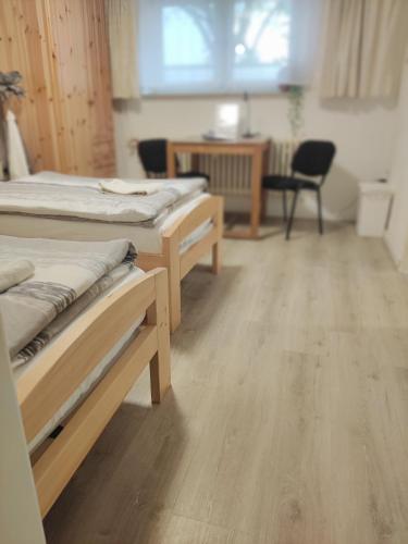 a room with three beds and a table and a chair at Unterkunft Ramser in Bad Eilsen