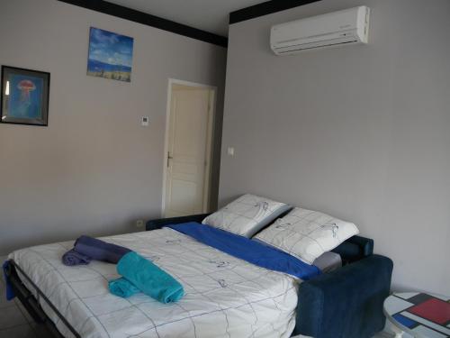 a bedroom with a bed with a blue pillow on it at L'Enclos de La Grande Flûte 