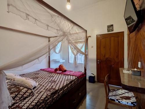 a bedroom with a canopy bed and a chair at ZEN MOON Hostel in Yogyakarta