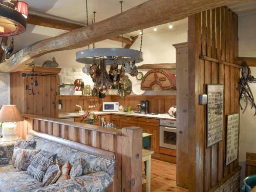 a living room with a couch and a kitchen at The Old Sheaf Store - Kyz in Glaisdale