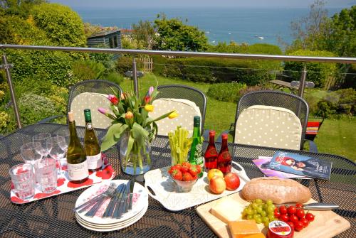 une table avec des bouteilles de vin et de la nourriture dessus dans l'établissement Seascape, à New Quay