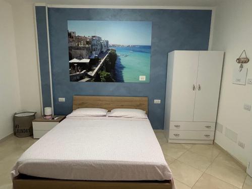 a bedroom with a bed with a painting on the wall at Masseria Causio in Giurdignano