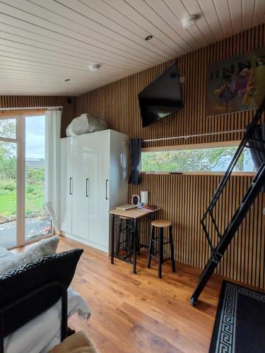 a living room with a staircase and a table in it at Hilltop Cabin in Cultra