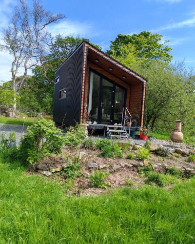 a tiny house sitting on top of a field at Hilltop Cabin in Cultra