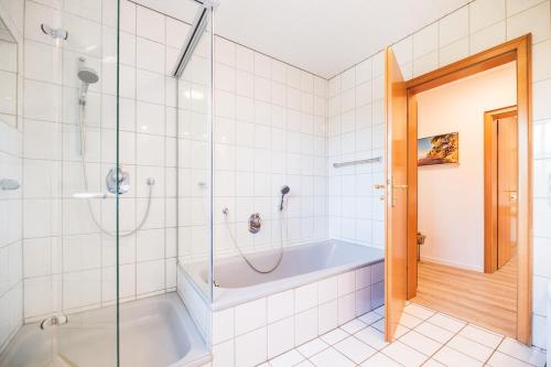 une salle de bain avec baignoire et douche en verre dans l'établissement Huus Binnensee - Ferienwohnung EG - Neue Tiefe, Fehmarn, à Fehmarn
