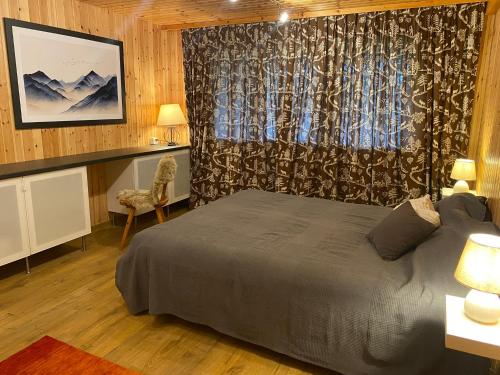 a bedroom with a bed and a desk and a window at Chalet Ardoise - Nature Paradise - Swiss Alps in Ovronnaz