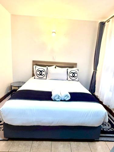 a bedroom with a bed with two stuffed animals on it at Emeli Hotel Luxury Suite in Nairobi