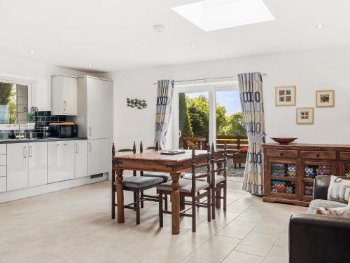 a kitchen and dining room with a table and chairs at Seaborne Cottage - Pwlheli in Pwllheli