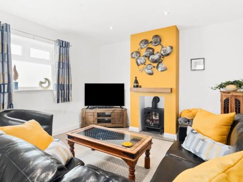 a living room with a couch and a coffee table at Seaborne Cottage - Pwlheli in Pwllheli