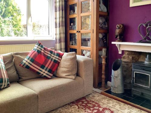 a living room with a couch and a fireplace at New House Farm Annexe in Neenton