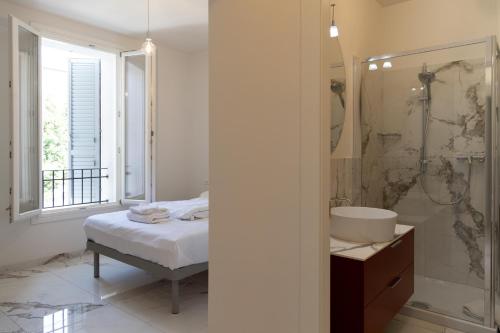 a bathroom with a bed and a sink and a shower at Astoria Guest House in Ravenna