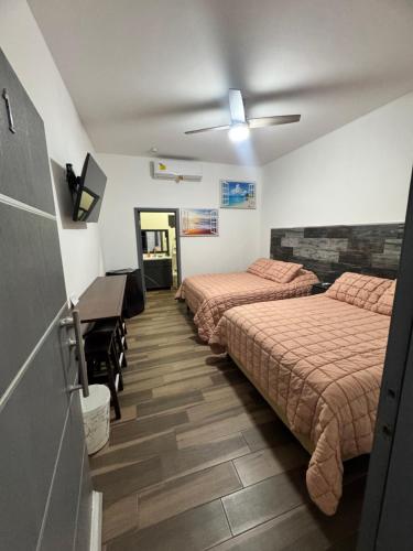 a room with two beds and a piano in it at Hotel Cuatro Palmas in Puerto Peñasco
