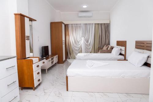 une chambre d'hôtel avec deux lits et une télévision dans l'établissement Juliana Royal Beach by Queen T, à Hurghada
