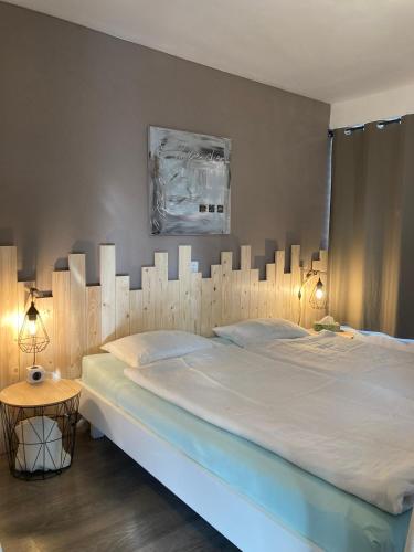 a bedroom with a large bed with a wooden headboard at Bnb Pavillon Paisible in Orsonnens