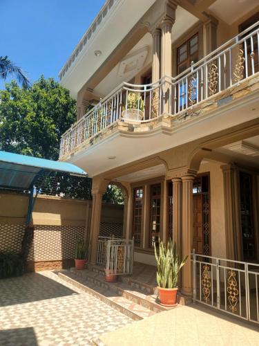 a large house with a balcony and potted plants at Cape Villa in Arusha