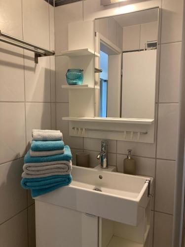 a bathroom with a sink and a mirror and towels at Bnb Pavillon Paisible in Orsonnens