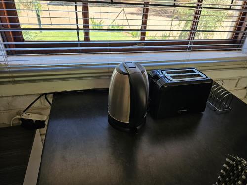 a toaster sitting on a table next to a window at Lalapanzi Accommodation in Vosburg