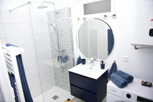 a bathroom with a shower and a sink and a mirror at La Manutention in Saumur