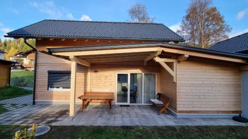 ein Pavillon mit einem Picknicktisch und einer Bank auf einer Terrasse in der Unterkunft Felsenfest Cottage in Kötschach
