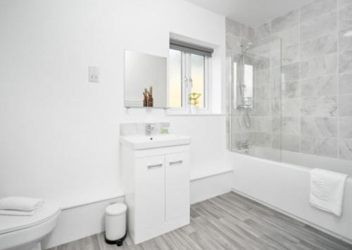 een witte badkamer met een toilet, een bad en een wastafel bij Stylish 2 Bed Apartment - Smart TV - WiFi - Parking 27C in Sleightholme