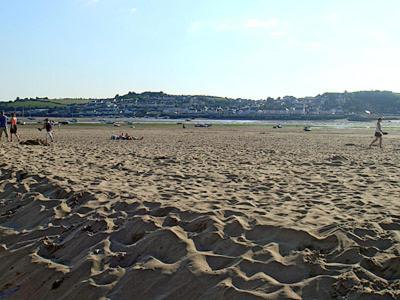 a group of people walking on a sandy beach at Waters Edge in Instow