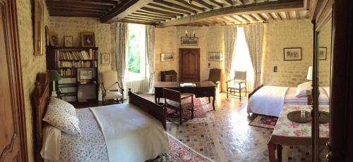 une chambre avec un lit et un bureau dans l'établissement Le Château d'Asnières en Bessin, à Asnières-en-Bessin