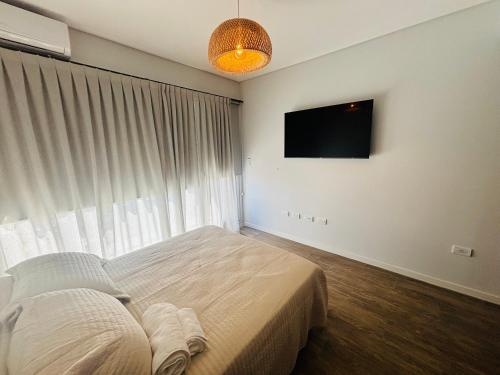 a bedroom with a bed and a flat screen tv at Studio 16 Neuquén in Neuquén