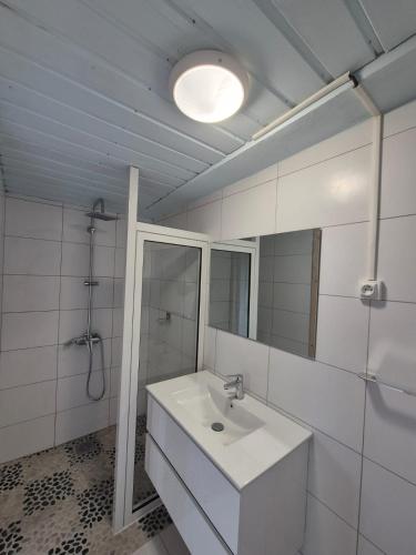 a white bathroom with a sink and a mirror at Chalet Les Planifolias in Saint-Philippe