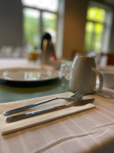 una mesa con un cuchillo, un tenedor y un plato en B&B De Zandput, en Balen