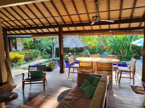 a patio with a couch and a table and chairs at Charming Balinese Holiday Home with private pool in lovina in Lovina