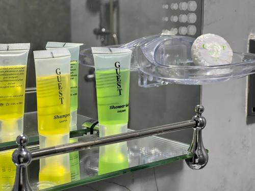 a glass shelf with four bottles of yellow liquid at Baku Center inn NS in Baku