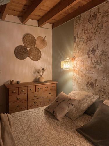 a bedroom with a bed and a dresser and a lamp at La Bastilac chambre Nature in Garganvillar