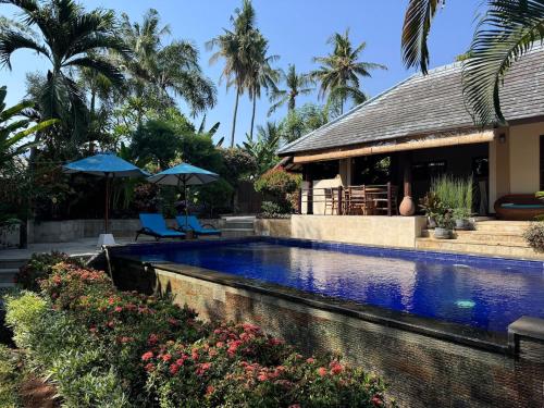a swimming pool in front of a house with a resort at Charming Balinese Holiday Home with private pool in lovina in Lovina