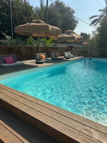 een groot zwembad met stoelen en parasols bij גארדן בוטיק צימר בכפר in Mishmar Hashiv‘ah