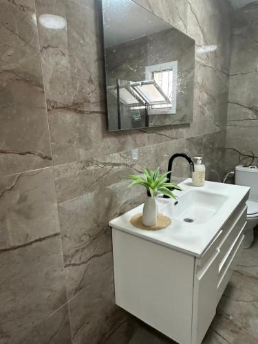 een badkamer met een witte wastafel en een spiegel bij גארדן בוטיק צימר בכפר in Mishmar Hashiv‘ah